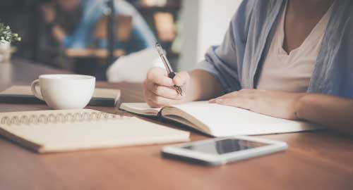 Person writing in notebook.